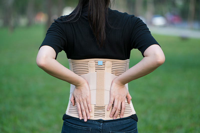 Posterior view of a man/woman wearing a back brace