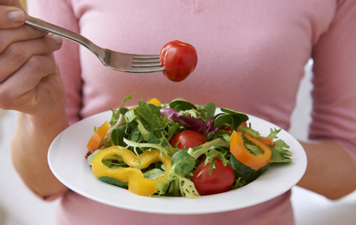 woman holding healthy plate of salad