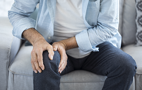man holding knee for pain